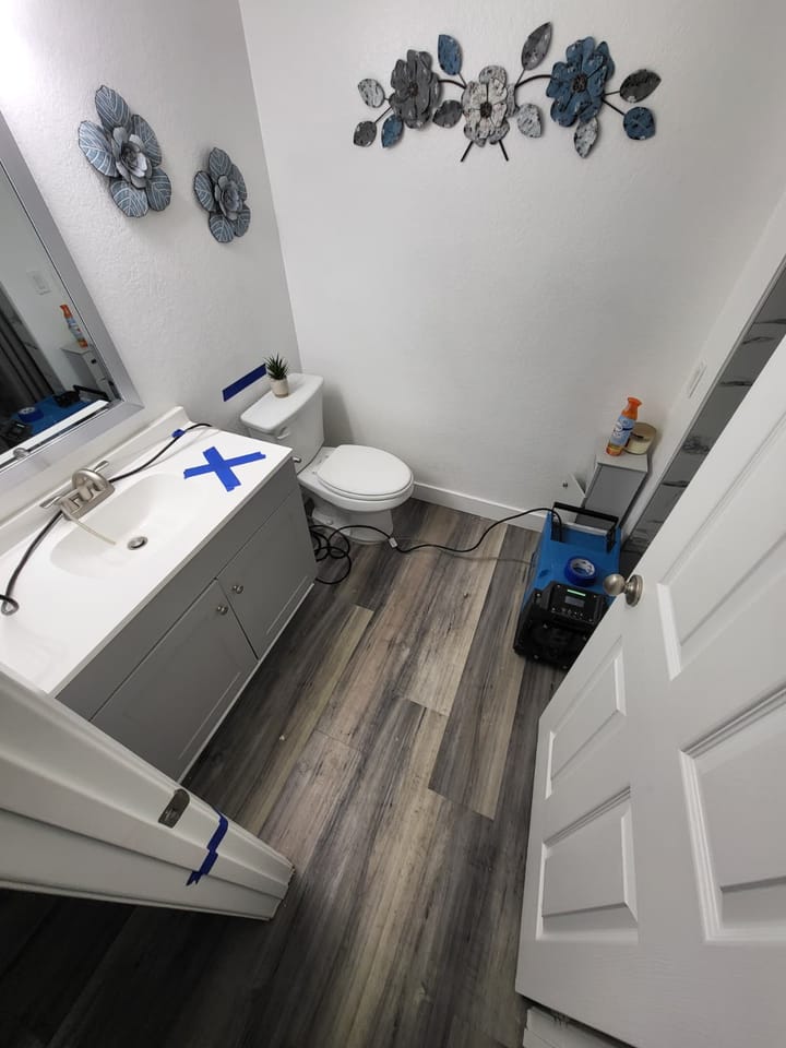 EMS crew documenting moisture damage in the hall bath, Riverside, CA.